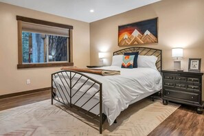 A stylish downstairs bedroom with a queen bed offers a cozy retreat to relax and recharge.