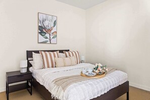 A second bedroom with a queen sized bed & plush pillows.
