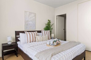 A master bedroom with a queen sized bed & plush pillows.