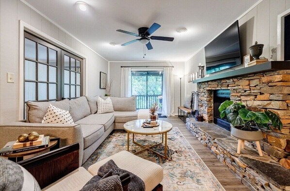 Living Room: Stylish lounge with a stone fireplace and scenic views—perfect for relaxation and fun!