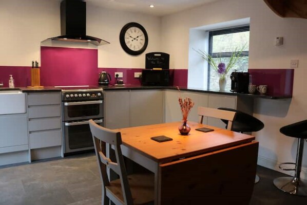 Modern kitchen with Granite surfaces, gas oven and hob, coffee machine.


