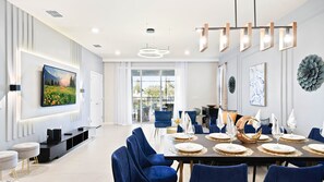 Bright and chic living space with elegant dining, plush seating, and patio views.