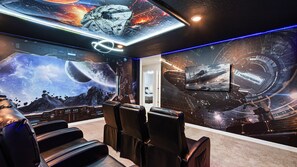 Immersive galaxy-themed theater room with recliners and epic sci-fi wall art.