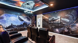 Immersive galaxy-themed theater room with recliners and epic sci-fi wall art.