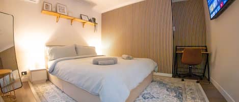 air conditioned studio with desk, full length mirror, tv and queen bed