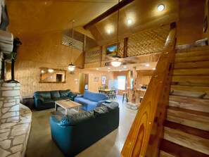 Hillside - Stunning living room has vaulted ceiling, polished concrete floors, cedar staircase, rock fireplace and is open concept for easy Frio River living.