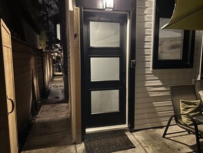 Well-lit walkway and entrance at night.