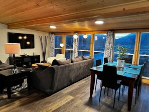 Living room with dining table behind couches and the mountain view.  