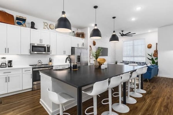 Huge kitchen on the main floor of the house with  a massive island, seating for 10, and all the appliances / supplies you'd need to cook a meal.