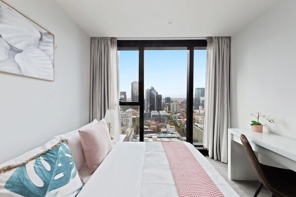 The master bedroom with a double sized bed & city views.