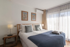 Relax in this cozy bedroom with natural light and stylish decor, perfect for a restful stay.