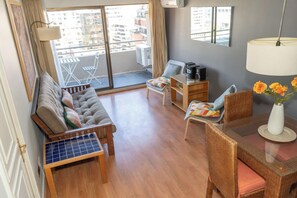 Bright and cozy living area with balcony access, perfect for relaxing and enjoying city views.