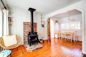 Open living room with wood-burning stove and dining area.