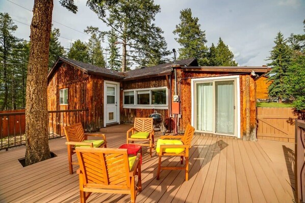 Exterior deck with seating and grill.