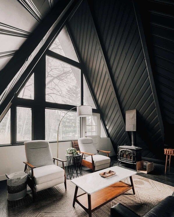 Living area with large windows (the wood-burning stove is decorative only and does not operate)