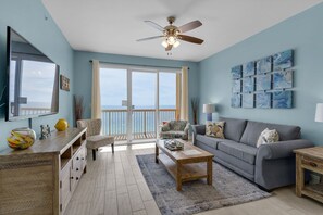 Living Room - Relax in luxury and comfort in this gorgeous living space featuring a large flat-screen TV, coastal decor, and a private balcony with breathtaking beach views.