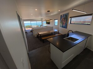 Kitchen view over dinning through living room over deck