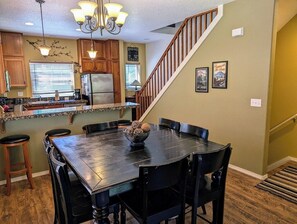 Large dining table with seating for 7 and a breakfast bar with 4 stools.