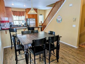 Large dining table with seating for 6, plus 2 stools at the breakfast bar