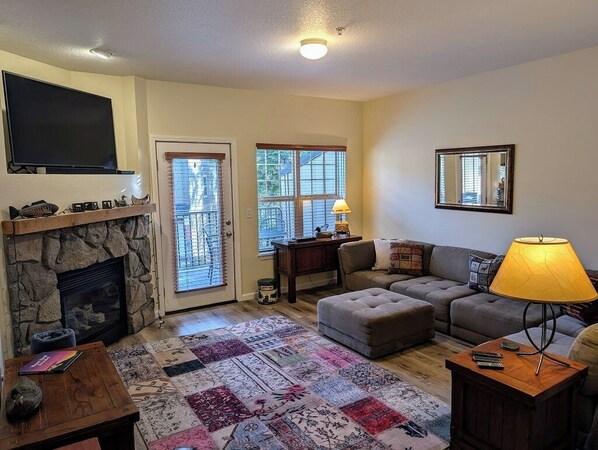 Cozy living room area with flat screen TV and gas fireplace.