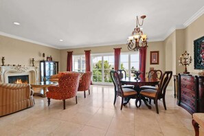 Step into the heart of the home—a spacious, sunlit living room with elegant furniture. The inviting seating is perfect for gatherings or quiet relaxation. Large windows flood the space with natural light, blending comfort and style effortlessly.