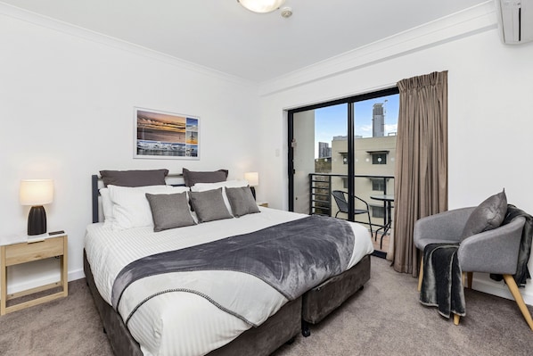Relax and unwind in this inviting king bed with balcony and city views.