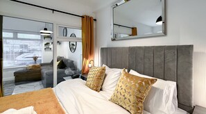 The bedroom has two single beds that can be joined to form a super king size bed. It also features a TV and a wardrobe.