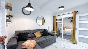 The living room features a double sofa bed and a 50-inch TV, preloaded with Netflix, Disney+, and Prime Video for your enjoyment.