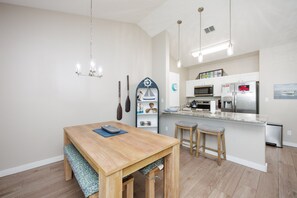 Fully equipped kitchen with a convenient breakfast bar and a charming rustic wooden table with a natural finish