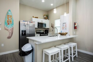 Bright dining area with modern appliances and three bar stools for entertaining