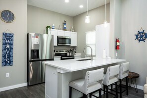 Dining area with modern appliances and three bar stools for entertaining