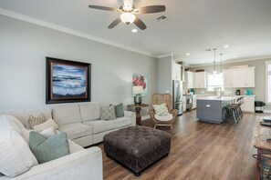 Living area with large sofa and flat screen TV located on second floor