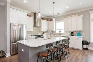 Open concept kitchen with barstools and coffee maker located on second floor