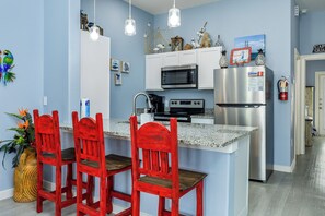 Dining area with modern appliances and three bar stools for entertaining