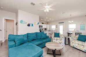 Expansive social first floor with a gourmet kitchen, dining area, and comfy living area