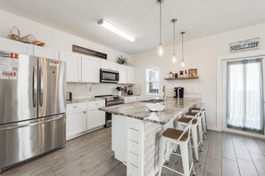 Fully equipped kitchen and breakfast bar with beautiful counter tops, plenty of cabinet storage and convenient appliances for guest use