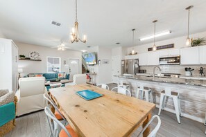 Traditional dining area with a beachside twist that opens up to the living and kitchen spaces for entertaining