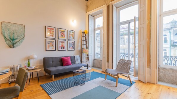 A spacious living room featuring comfortable seating arrangements, quirky decor and large windows, that allow the entrance of lots of natural light #bright #eccentric