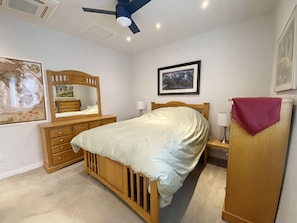 Queen size bed, 1 large dresser, ceiling fan & separate AC/Heater, & window.