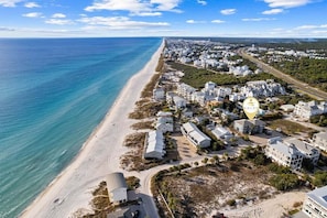 A serene view of golden sands and blue waves.