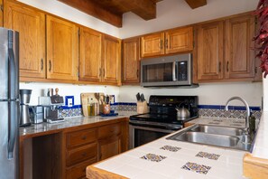 Kitchen includes blender, espresso machine, standard drip coffee machine, dish washer, and basic cooking supplies. 