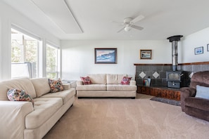 A comfortable living room with big windows and a big TV