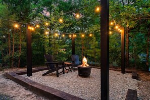 Decorative string lights around a firepit set the mood for some outdoor together time