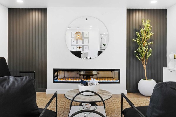 Front formal living room with comfortable seating and 74" electric fireplace
