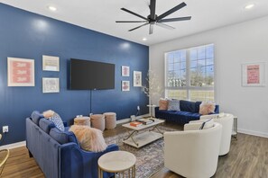 Living room with two comfy couches, a ceiling fan, and a Smart TV with all the streaming apps. Plenty of seating here & in the kitchen for your family to unwind.
