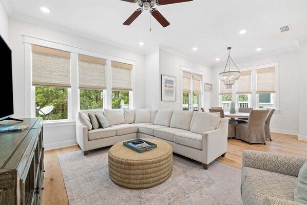 A comfortable and stylish living room with a large sectional, natural lighting, and a calming ambiance.
