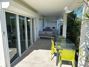 Outdoor dining area with views of the ocean and gardens.