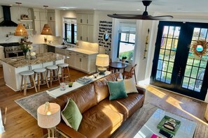 Living room french doors open to fully fenced, private, backyard oasis.