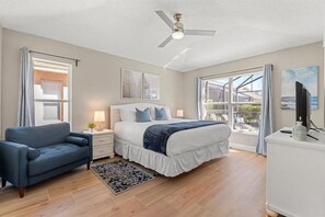 The master bedroom has a wide window overseeing the pool area, and a private ensuite bathroom
