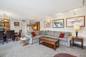 The open layout connects to the dining and kitchen areas, creating an inviting mountain retreat.